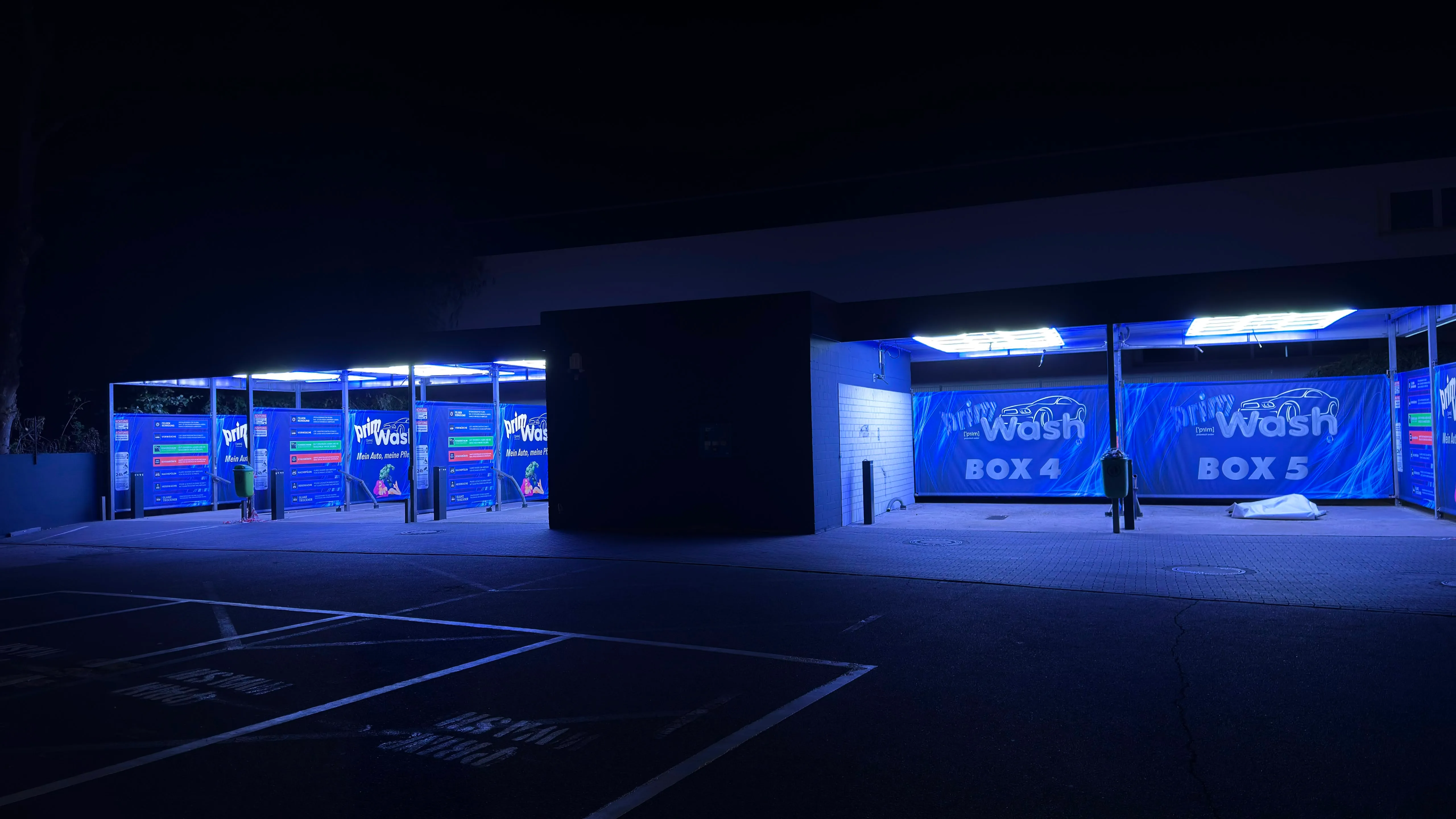 Prim Wash Standort Essen bei Nacht: fünf Waschboxen in blauem Licht, Box 4 und Box 5 im Vordergrund