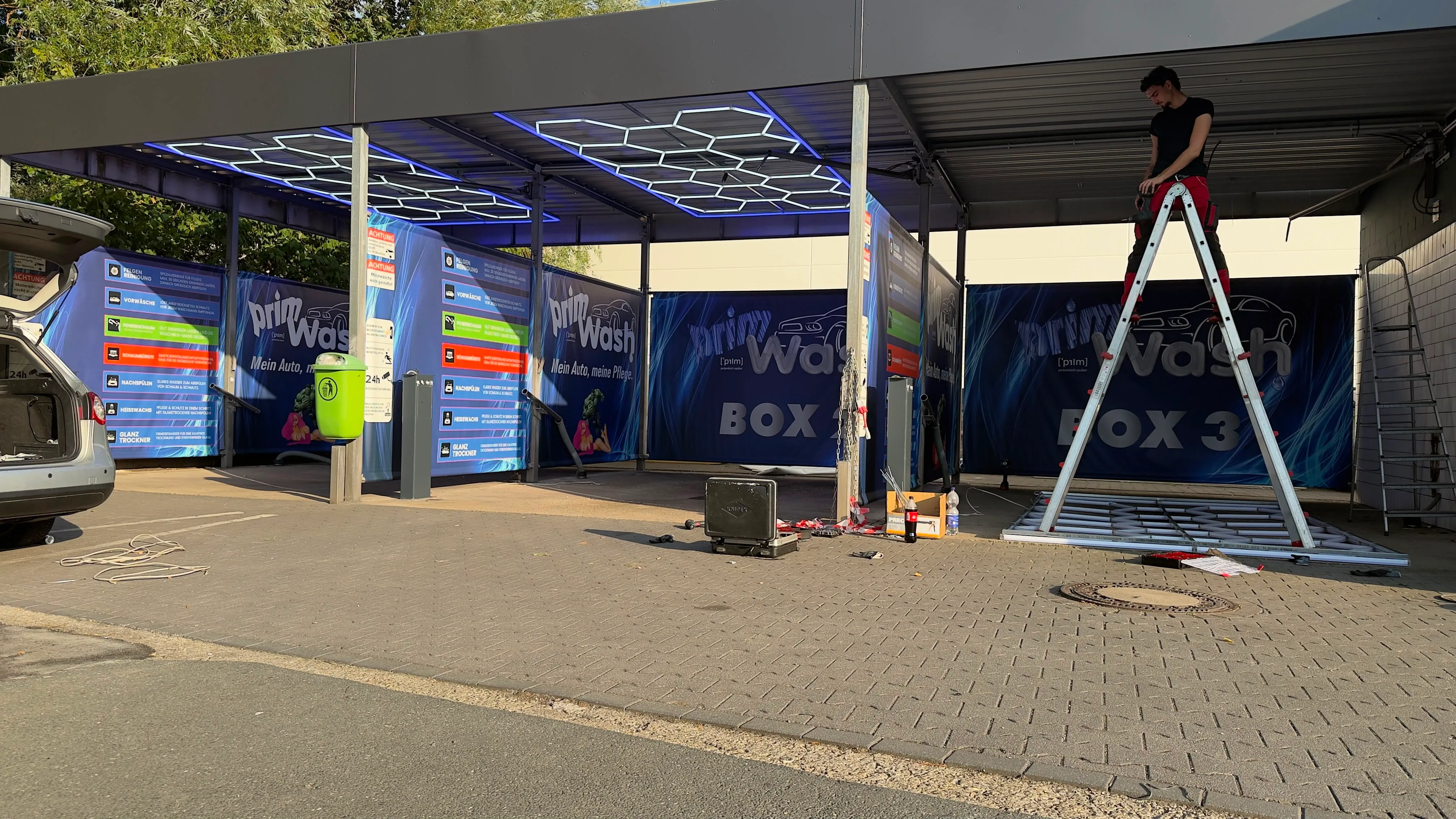 Montagearbeiten in den Waschboxen: Hexagon-LED-Beleuchtung an der Decke, Box 2 und Box 3 mit neuer Prim Wash Beschilderung